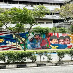 Kolorowy mural z flagą Malezji i uśmiechniętymi dziećmi. Wiza do Malezji może być pierwszym krokiem do zobaczenia tego piękna.