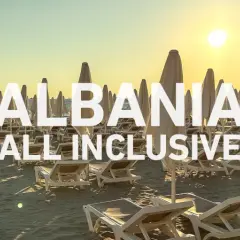 Albania - wczasy samolotem all inclusive. Słoneczna plaża z leżakami i parasolami, idealna na relaks.