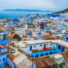 Niebieskie miasto Maroko, Chefchaouen, wznosi się na wzgórzu, tworząc malowniczy krajobraz z dachówkami i błękitnymi ścianami.
