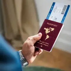 Dłoń trzyma paszport i bilet lotniczy. Planujesz podróż? Sprawdź, czy na Cypr potrzebny jest paszport.