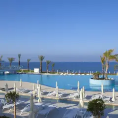 Luksusowy basen z palmami i widokiem na morze. Idealne miejsce na relaks, zgodnie z licznymi king evelthon beach hotel and resort opinie.