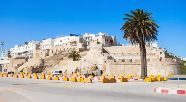 Agadir w marcu: słoneczna pogoda, białe budynki na wzgórzu, palmy i forteca.