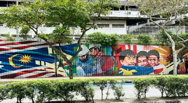 Kolorowy mural z flagą Malezji i uśmiechniętymi dziećmi. Wiza do Malezji może być pierwszym krokiem do zobaczenia tego piękna.