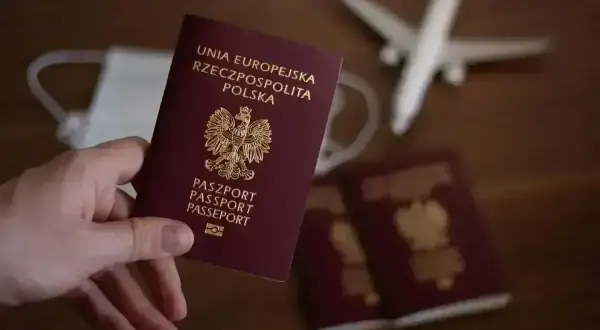 Paszport jest niezbędny, by podróżować do Anglii. Na zdjęciu polski paszport, maseczka i samolot.