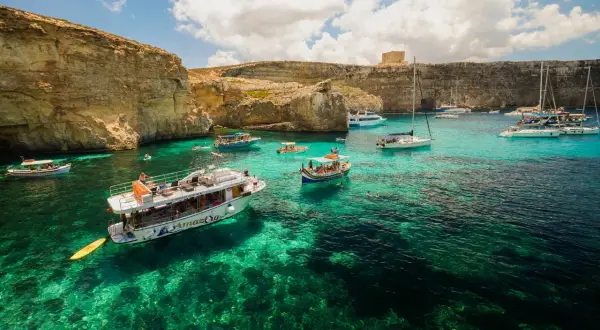 Malta, wrzesień: turkusowa woda, klify i łodzie w Zatoce Błękitnej. Idealna pogoda na rejs.