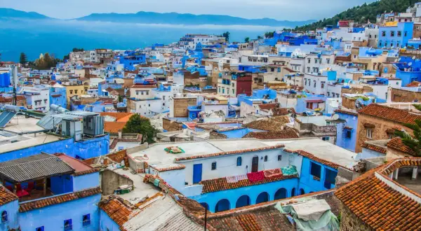 Niebieskie miasto Maroko, Chefchaouen, wznosi się na wzgórzu, tworząc malowniczy krajobraz z dachówkami i błękitnymi ścianami.