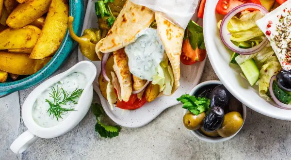 Grecka uczta: gyros, frytki, sałatka grecka, oliwki i sos tzatziki.
