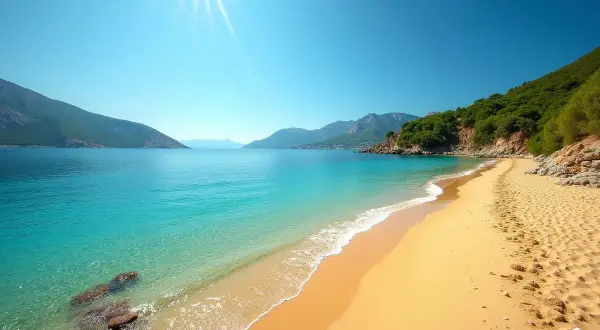 Plaża z turkusową wodą, piaszczystym brzegiem i zielonymi wzgórzami w tle.