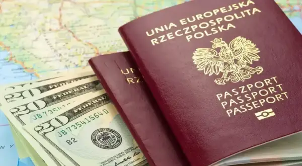 Dwa polskie paszporty, banknoty dolarowe i mapa. Planujesz podróż? Sprawdź, czy do Serbii potrzebny jest paszport.