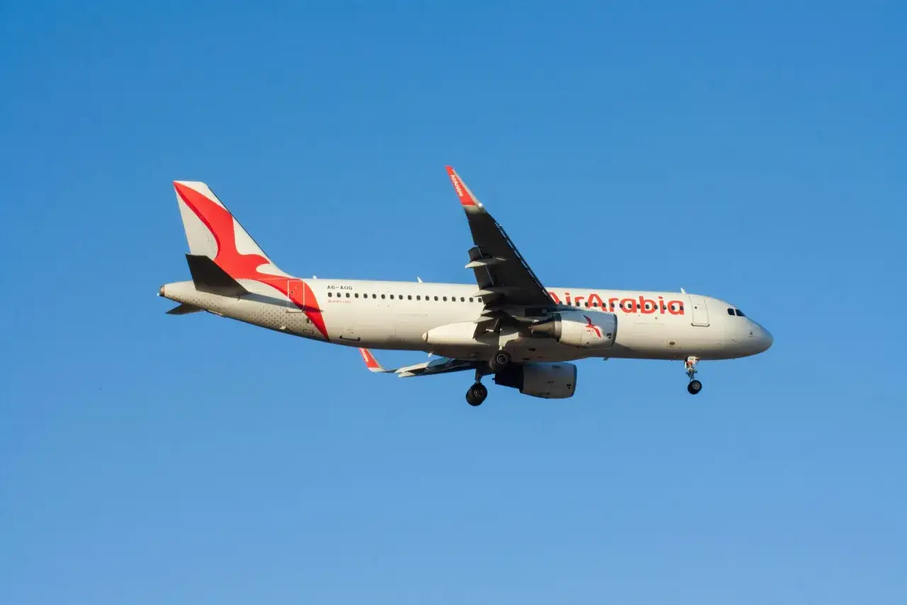 Samolot Air Arabia z wysuniętym podwoziem, gotowy do lądowania. Wiele osób szuka pozytywnych air arabia opinie przed podróżą.