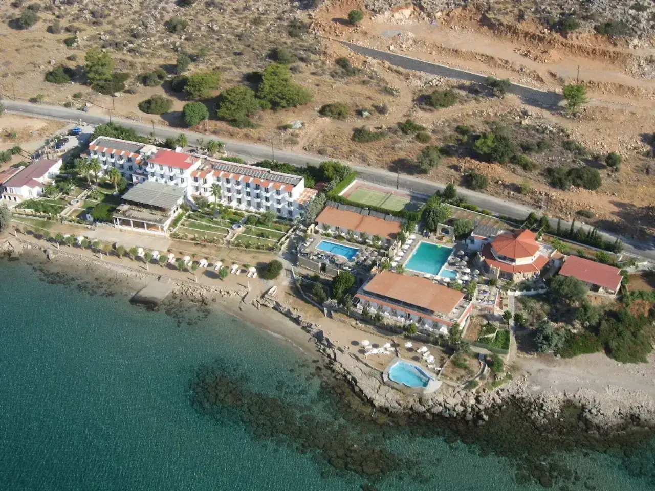 Widok z lotu ptaka na hotel Ilysion z basenami, kortem tenisowym i plażą. Wiele pozytywnych ilyssion hotel opinie potwierdza jego urok.