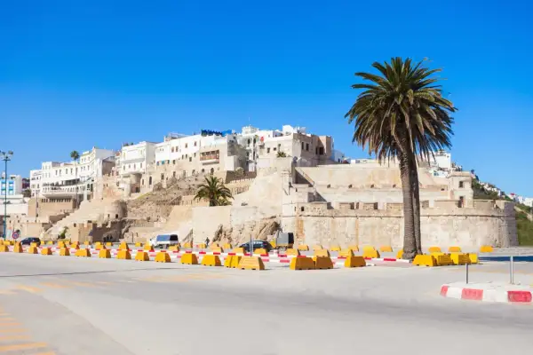 Agadir w marcu: słoneczna pogoda, białe budynki na wzgórzu, palmy i forteca.