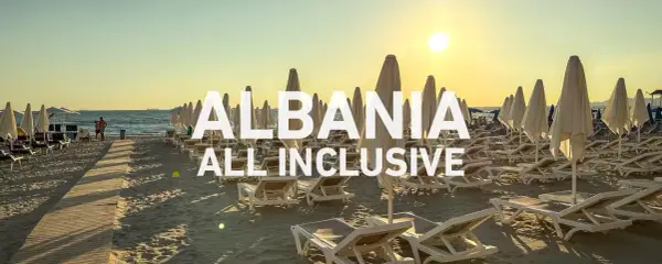 Albania - wczasy samolotem all inclusive. Słoneczna plaża z leżakami i parasolami, idealna na relaks.