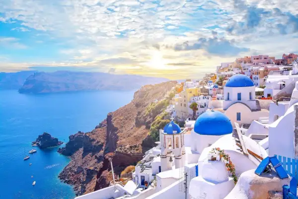 Widok na białe domy z niebieskimi kopułami na klifie nad morzem, Santorini, Grecja.