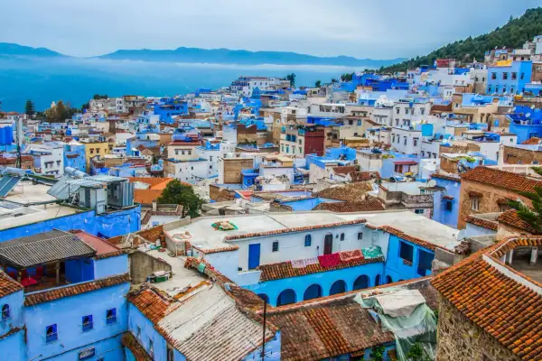 Niebieskie miasto Maroko, Chefchaouen, wznosi się na wzgórzu, tworząc malowniczy krajobraz z dachówkami i błękitnymi ścianami.