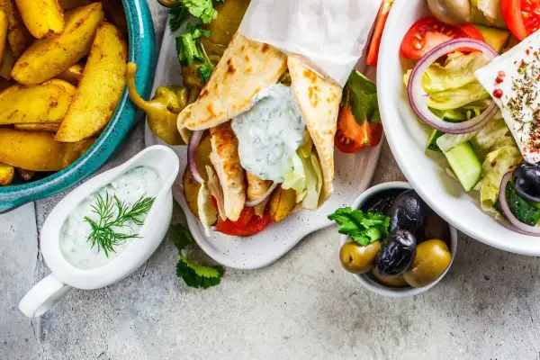 Grecka uczta: gyros, frytki, sałatka grecka, oliwki i sos tzatziki.