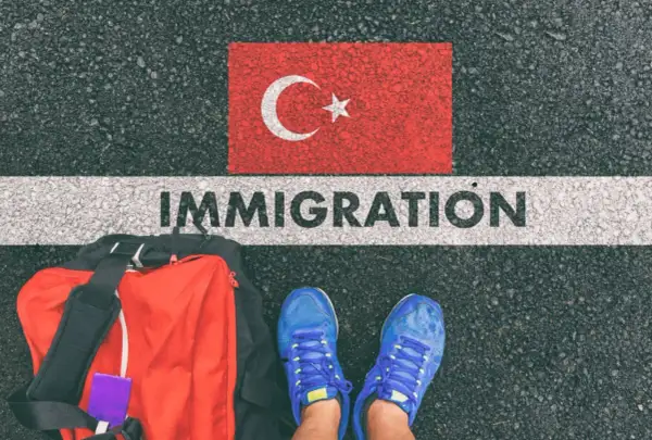 Bagaż i buty na tle flagi Turcji i napisu IMMIGRATION. Czy Turcja jest w Schengen?